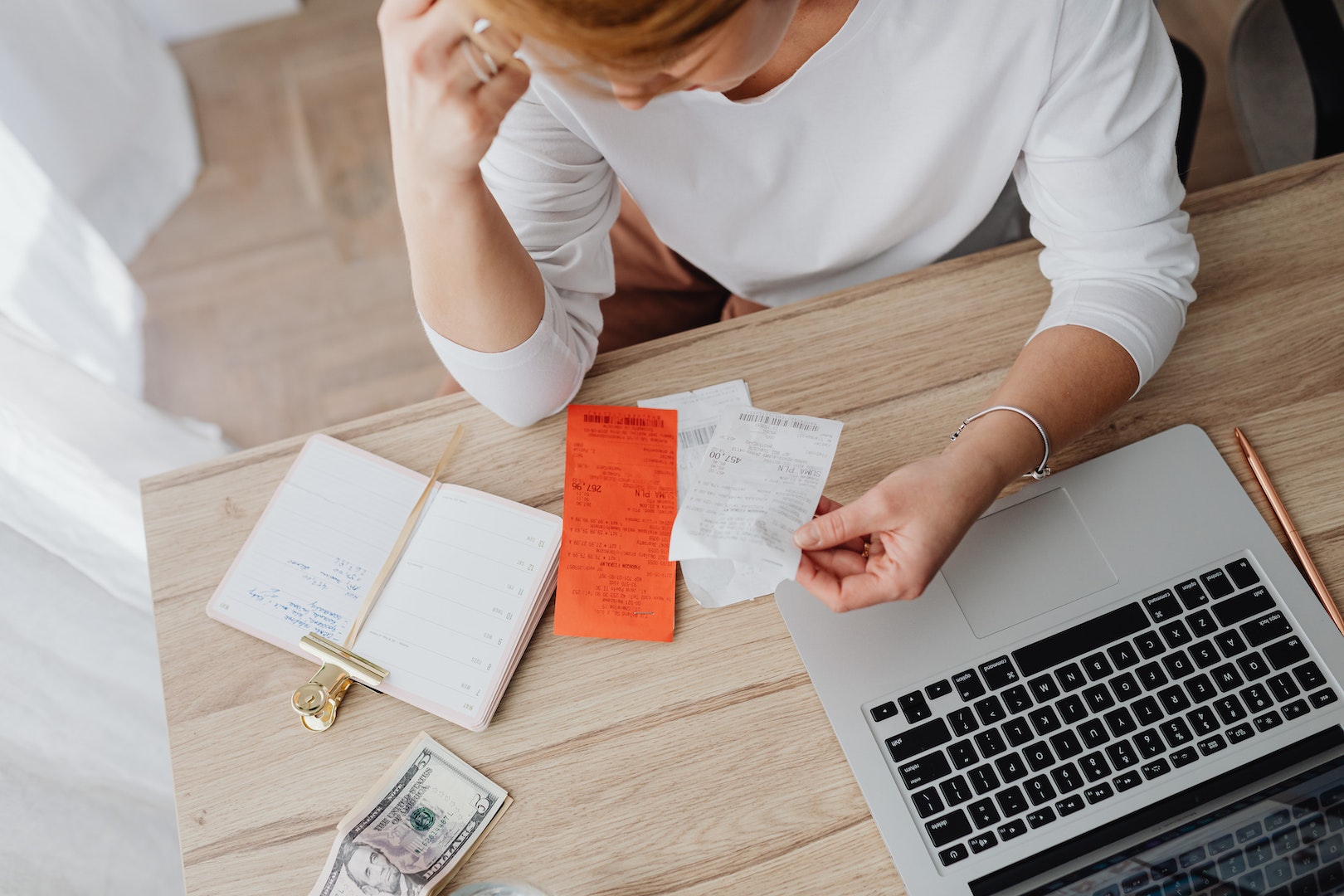 Woman Sitting Behind the Desk and Looking at Receipts 