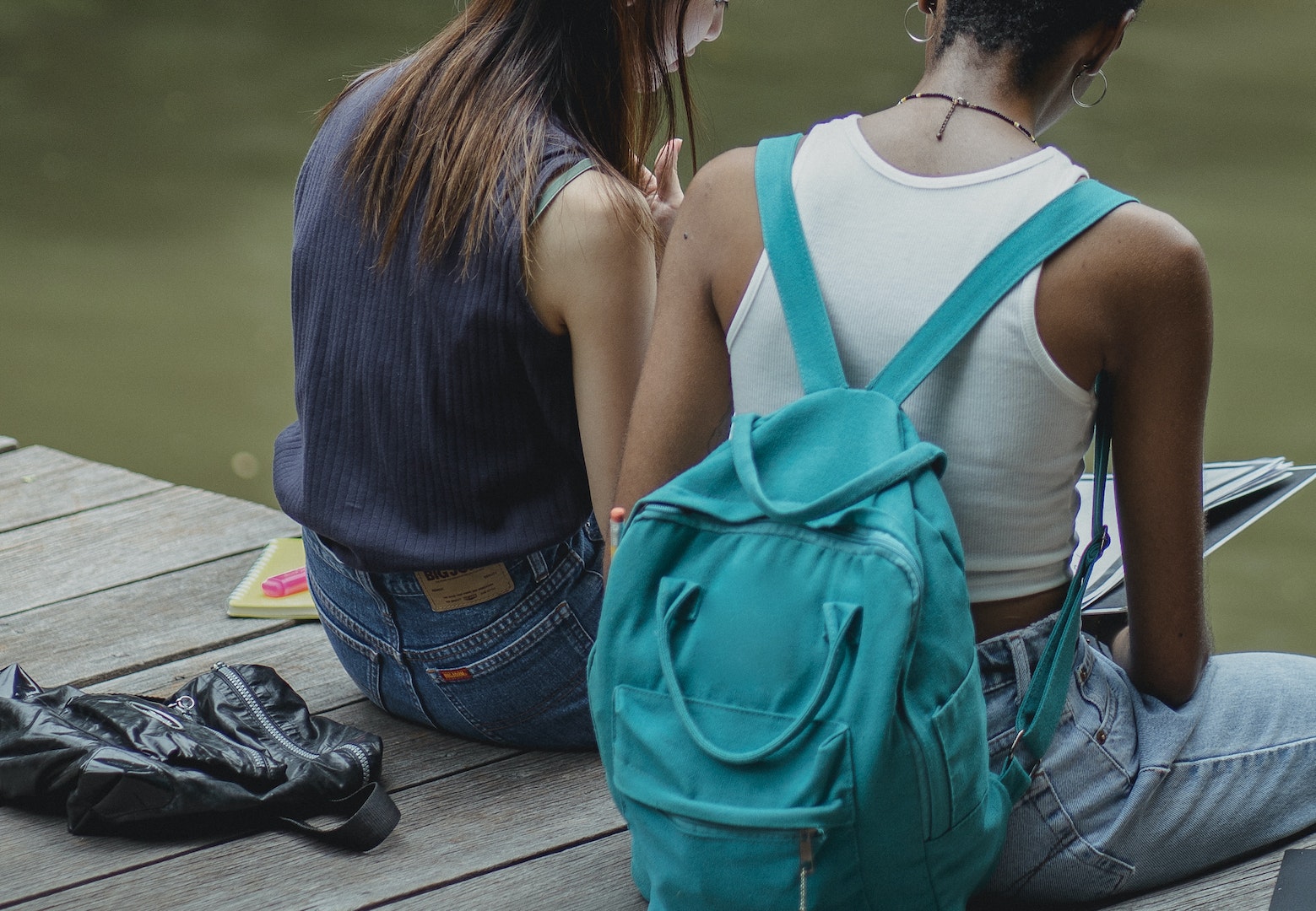 Crop unrecognizable diverse students working on assignment in park