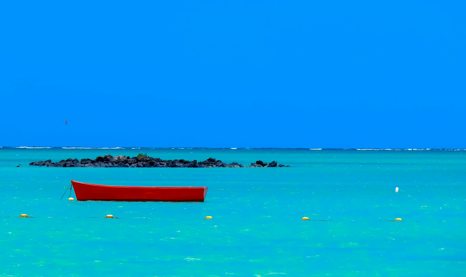 un bateau rouge dans les eaux magnifiques de Maurice