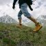 Randonneur gravissant un sentier de montagne verdoyant en chaussures de marche
