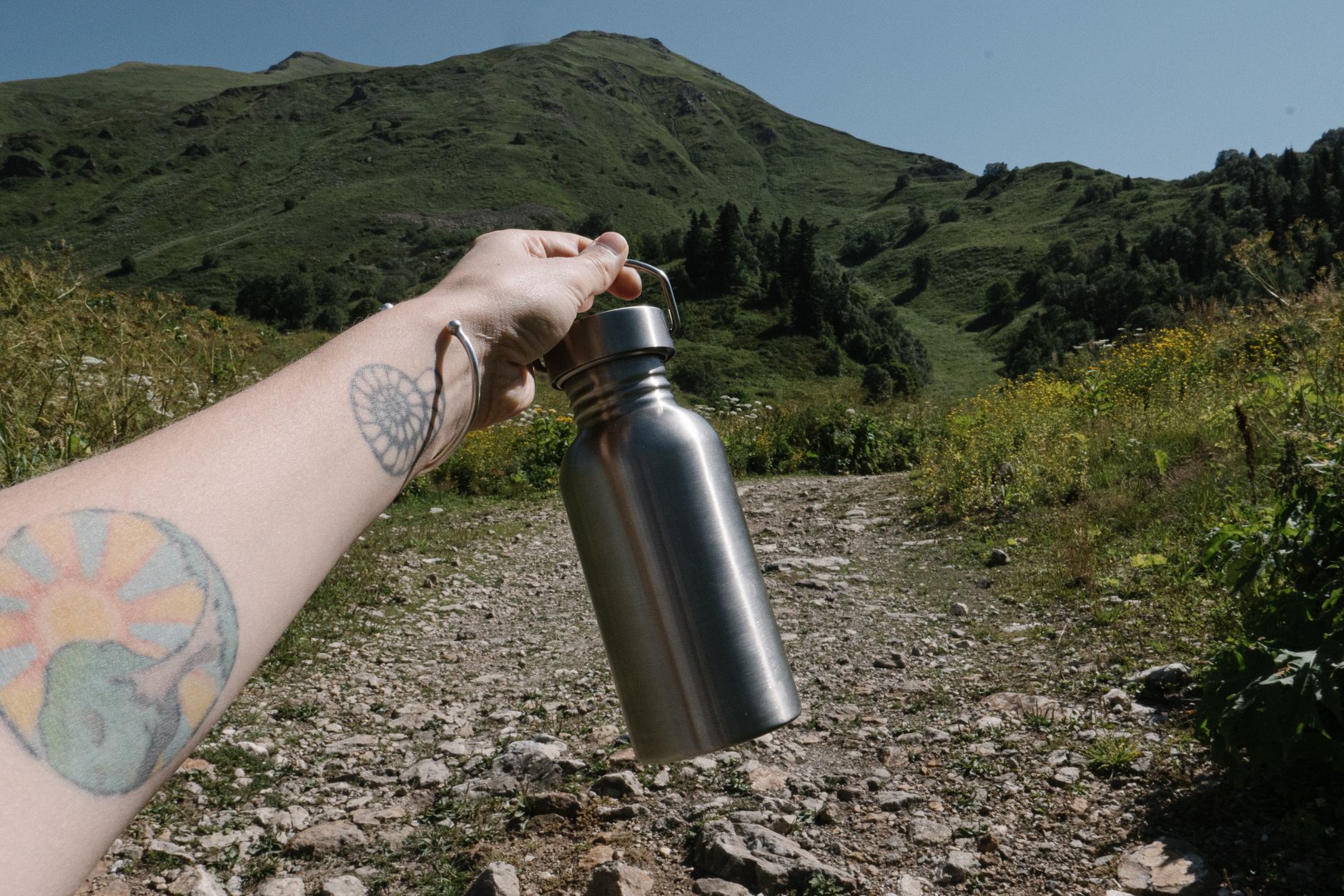 Randonneur tenant une gourde en montagne