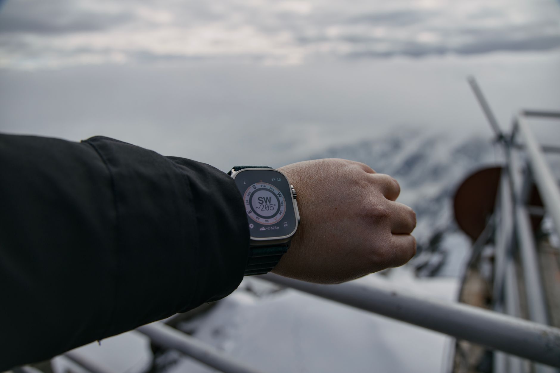 Randonneur consultant une montre boussole en environnement neigeux