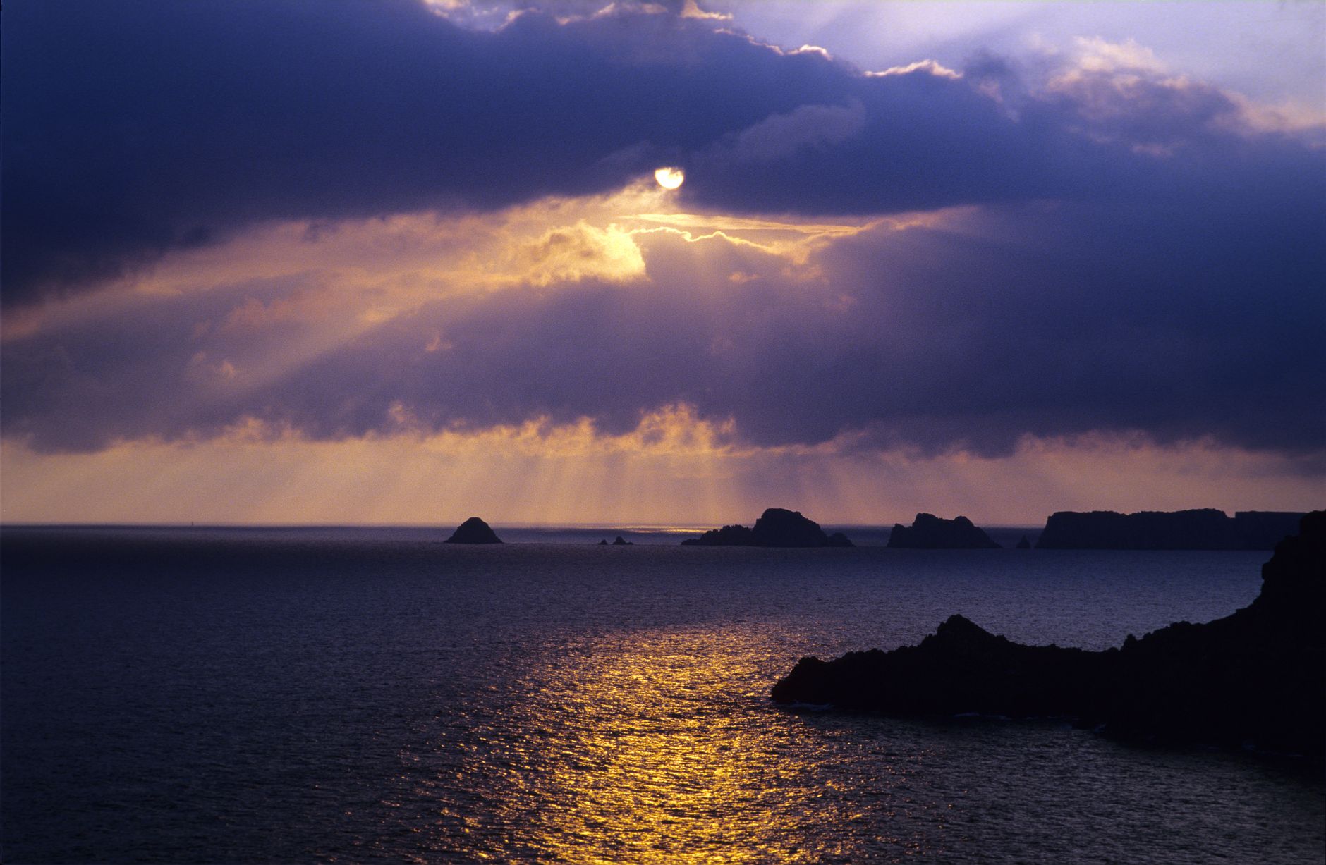 Coucher de soleil sous un ciel chargé au-dessus de la mer d'Iroise, depuis la presqu'île de Crozon