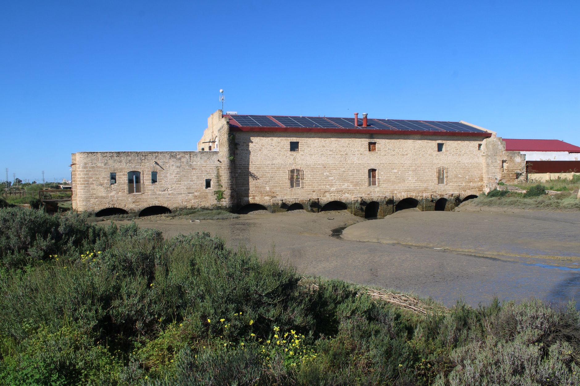 Ancien moulin à marée en pierre à El Puerto de Santa María (Andalousie), arches du soubassement au-dessus d'un chenal envasé à marée basse